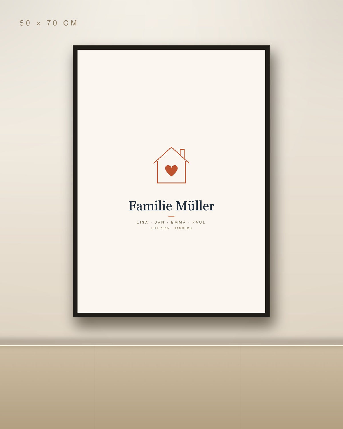 Personalisiertes Familienposter mit Haus und Herz 50 × 70 cm mit schwarzem Rahmen an Wohnzimmerwand über Holz-Sideboard